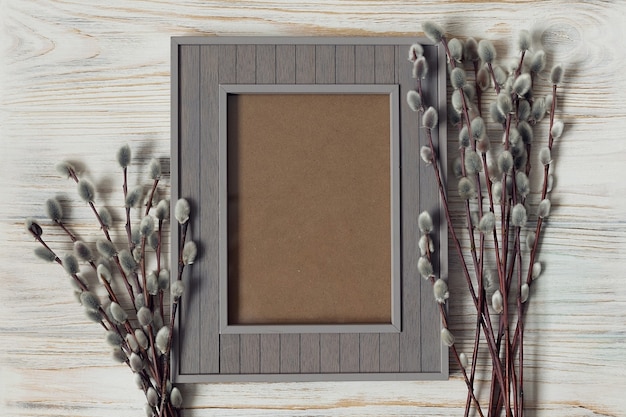 Mockup di auguri di Pasqua, cornice grigia su fondo di legno bianco. Foto di alta qualità