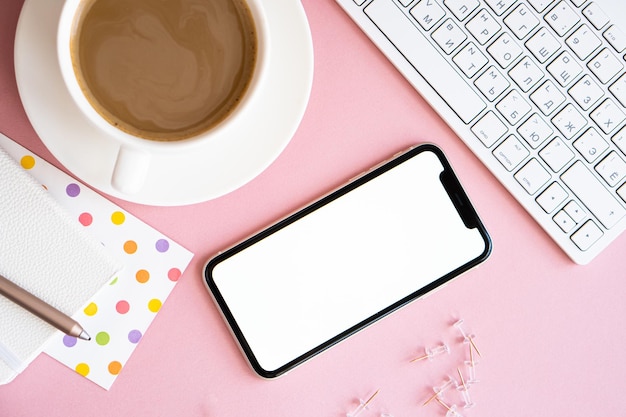 Mockup di caffè e smartphone sul posto di lavoro rosa pastello per la casa della signora freelancer