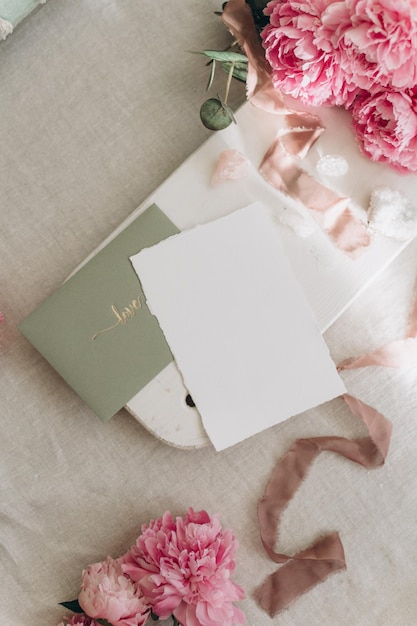 Mockup di cartolina sullo sfondo di fiori di peonie su sfondo chiaro