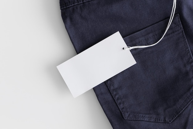 Mockup di etichetta di abbigliamento bianco su pantaloni blu