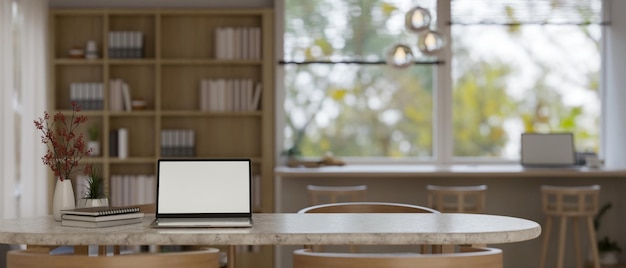 Mockup di laptop e copia spazio su un tavolo in una stanza di coworking confortevole e minimale