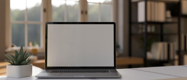 Mockup di laptop sul tavolo da lavoro bianco su sfondo sfocato della stanza di lavoro domestica