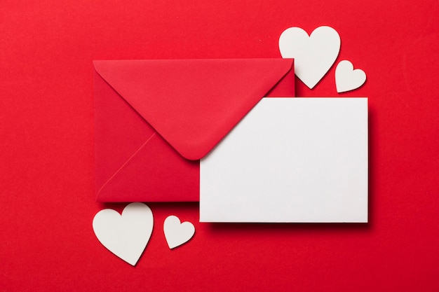 Mockup di lettera d'amore di San Valentino Busta rossa vuota carta bianca e cuori