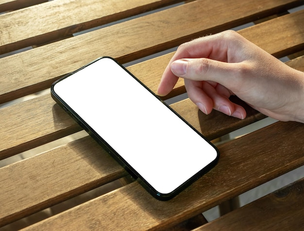 Mockup di mano e telefono cellulare sullo scorrimento del tavolo in legno