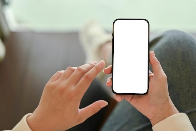 Mockup di smartphone nella mano di una donna su sfondo sfocato primo piano immagine vista dall'alto