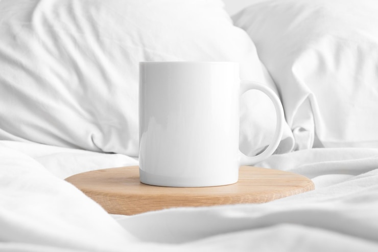Foto mockup di tazza bianca sul letto