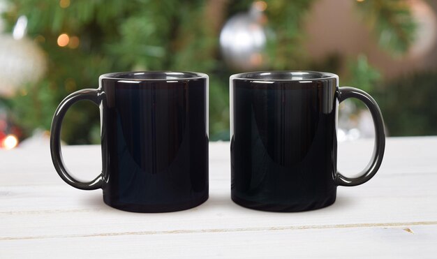 Mockup di tazza da caffè nero da 11 once Due tazze in scena ispirata alle vacanze con albero di Natale