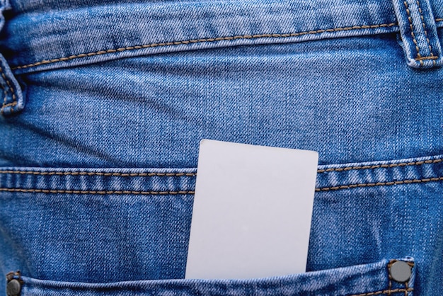 Mockup di un'etichetta in bianco di carta nella tasca sul primo piano delle blue jeans