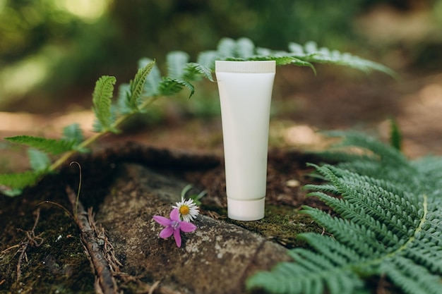 Mockup di un tubo per crema su uno sfondo naturale nella foresta, un prodotto ecologico