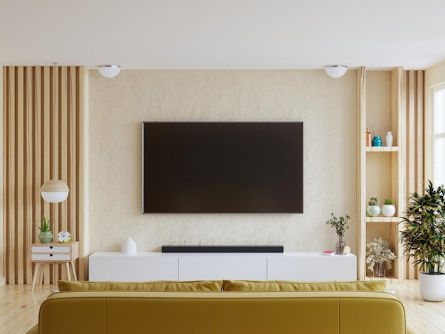 Mockup di una TV montata a parete con divano giallo in soggiorno con una parete bianca