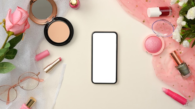 Mockup di uno schermo vuoto per smartphone su sfondo bianco con cosmetici di bellezza rosa femminili