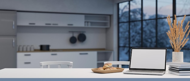 Mockup per laptop su un tavolo da pranzo bianco con spazio per la copia su cucina sfocata sullo sfondo