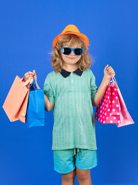 Moda bambino sullo shopping Ritratto di un bambino con le borse della spesa Ragazzo felice azienda borse della spesa Ritratto in studio