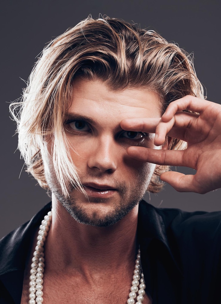 Foto moda di bellezza e ritratto dell'uomo con le mani in posa per gioielli cosmetici e trucco su sfondo scuro zoom facciale estetico creativo e modello neutro di genere per lo stile di tendenza e di lusso del designer