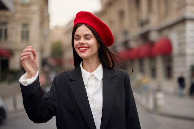 Moda donna ritratto sorriso con denti in piedi sulla strada di fronte al turista della città in abiti eleganti con labbra rosse e berretto rosso viaggio colore cinematografico retrò stile vintage moda urbana