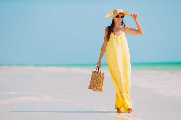 Moda giovane donna in abito verde sulla spiaggia