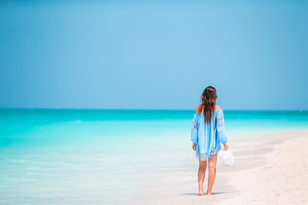 Moda giovane donna in abito verde sulla spiaggia