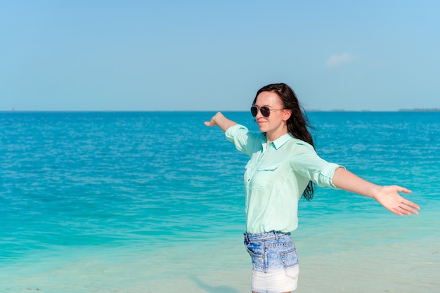 Moda giovane donna in abito verde sulla spiaggia