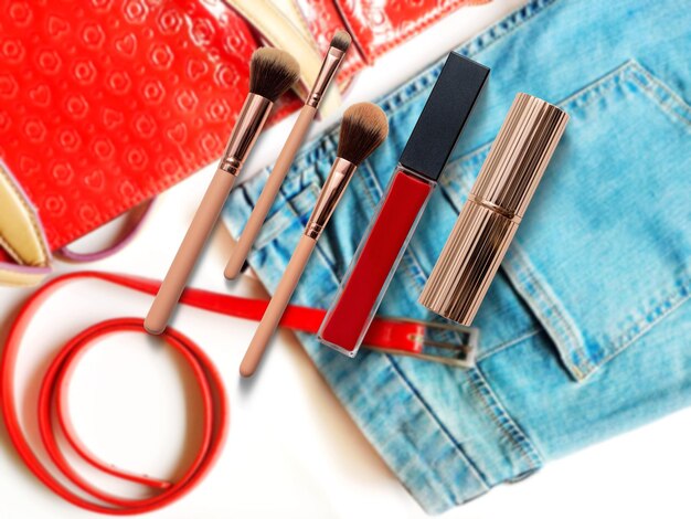 moda Gli accessori delle donne compongono la matita della tavolozza del rossetto rosso sulla moda del fondo blu cosmetico