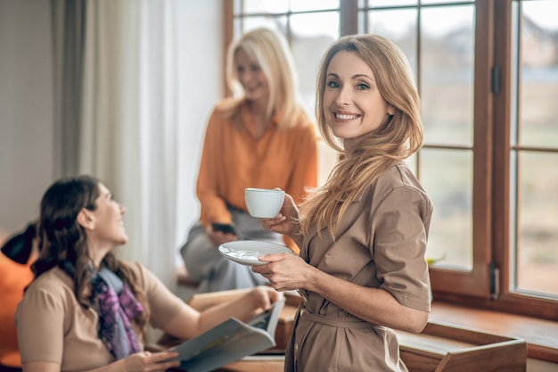 Moda. Gruppo di donne che trascorrono del tempo insieme e guardano attraverso la rivista di moda