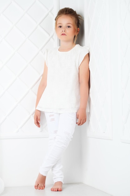 Moda per bambini Bella ragazza bionda seria pensosa in whi