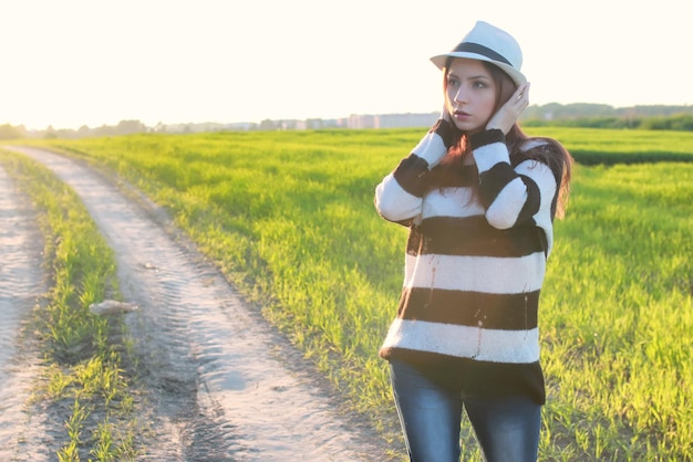 Moda ragazza in campo al tramonto