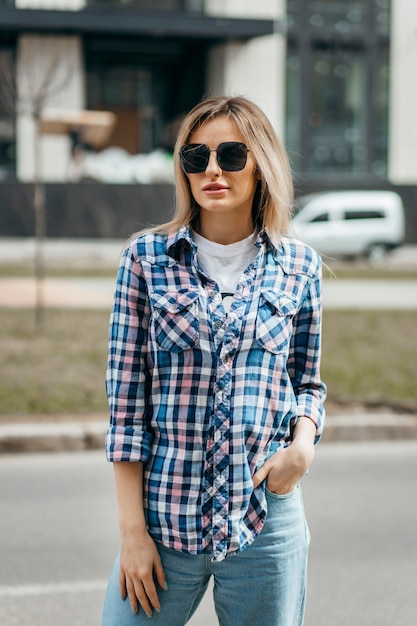 Moda ritratto di bella donna con bel viso che indossa la camicia a quadri grunge in posa da solo