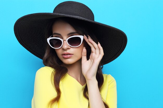 Moda ritratto di giovane donna che indossa cappello e occhiali da sole.