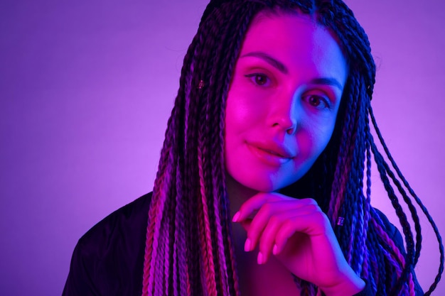 Moda ritratto di giovane donna con i dreadlocks alla luce al neon