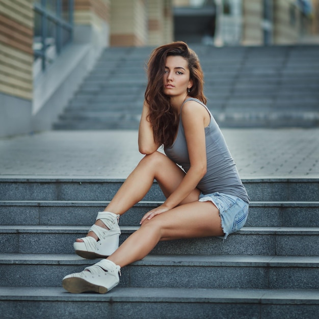 Moda ritratto di giovane donna modello su sfondo urbano