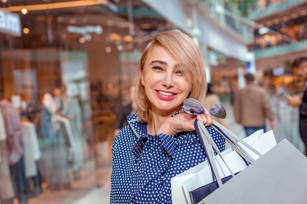 Moda Shopping Girl Ritratto Bellezza Donna con borse della spesa nel centro commerciale Shopper Sales Shopping Center