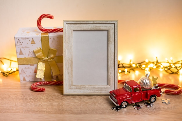 Modello bianco della cornice del ritratto con i regali di natale, luci boken Foto di alta qualità