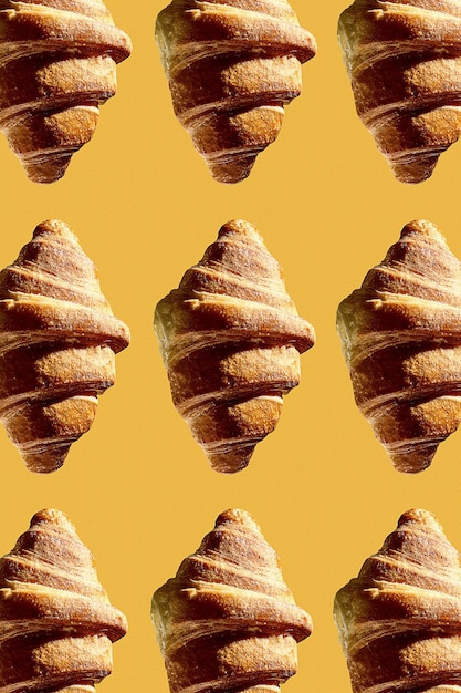 Modello con un croissant su sfondo giallo. Croissant appena sfornati per colazione. Mosca creativa