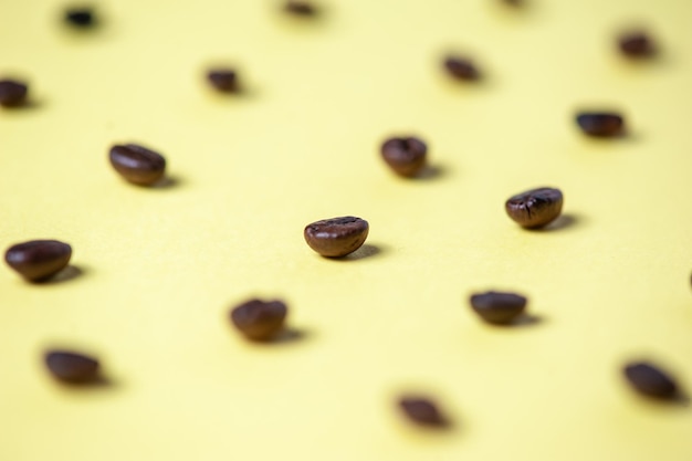 Modello creativo di chicchi di caffè su sfondo giallo Vista dall'alto