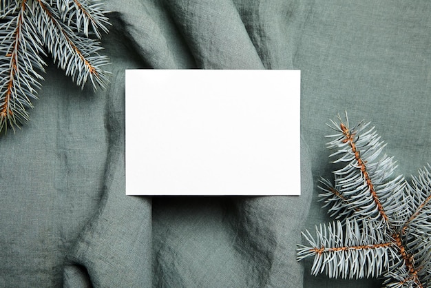 Modello della cartolina d'auguri di Natale con i rami di abete sulla vista superiore del fondo del panno verde