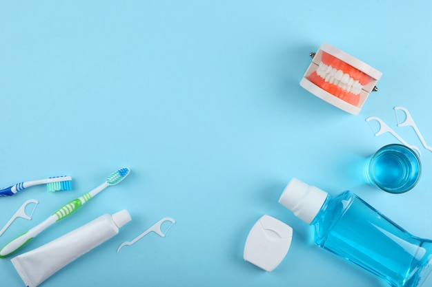 Modello dentale di denti e prodotti per la cura dei denti su sfondo colorato