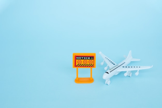 Modello di aeroplano bianco con segnale di divieto su sfondo blu per veicolo e trasporto nel concetto di situazione coronavirus o Covid-2019