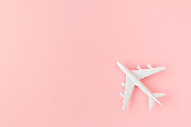 Modello di aeroplano bianco su sfondo rosa vista dall'alto banner piatto