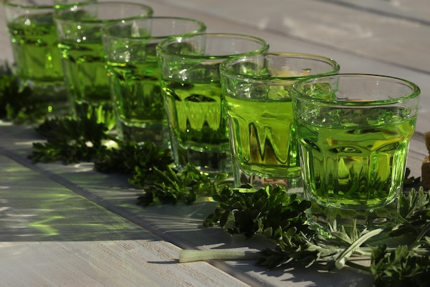 modello di bevanda di assenzio verde su fondo di legno bianco con spazio di copia