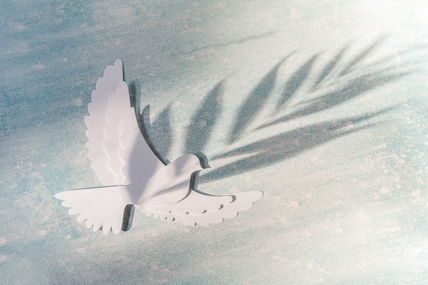 Modello di biglietto di auguri per la giornata mondiale della pace. Colomba che vola sul blu.