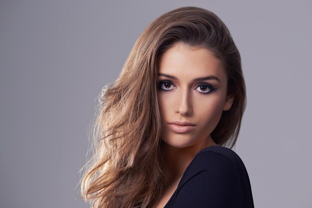Modello di capelli e ritratto in studio per il trattamento di salone e luce su sfondo grigio isolato Shampoo sicuro e viso di persona femminile con cosmetici naturali acconciatura e volume nello spazio di mockup