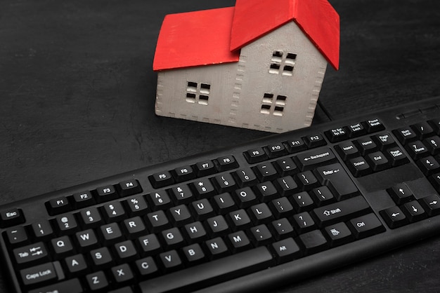 Modello di casa e tastiera. Affitto immobiliare on line. Cerca alloggio su Internet.