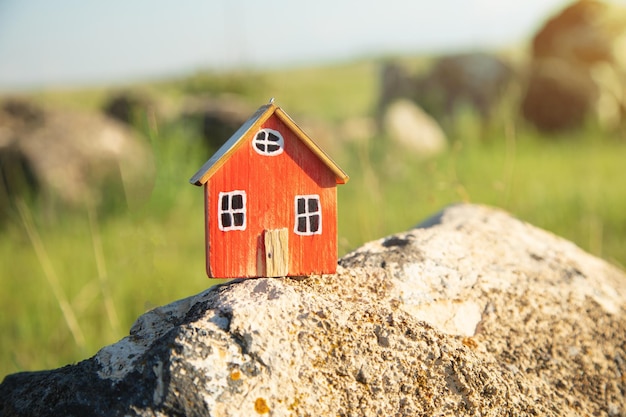 Modello di casa su sfondo verde erba Concetto di casa ecologica