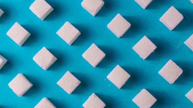 Modello di cibo piatto vista laici con zucchero bianco su carta blu.
