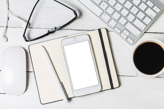 Modello di documenti in bianco per i progettisti. Mockup di design responsabile su sfondo in legno vintage. Carta, intestazione, tazza di caffè, smartphone, matita e cuffie sullo sfondo della tabella di legno. Vista dall&#39;alto.