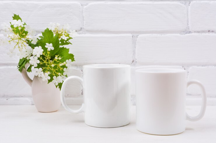 Modello di due tazze di caffè bianco con fiori di viburno