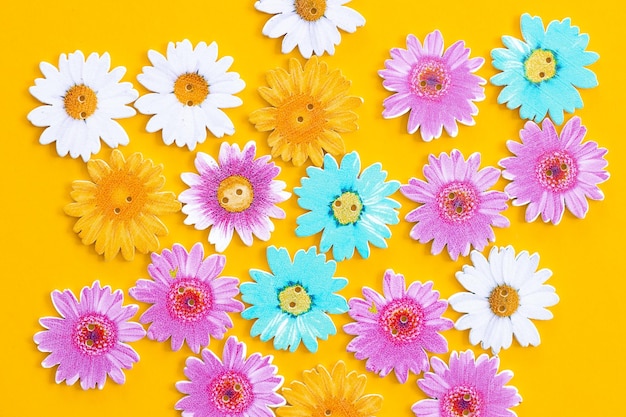 Modello di fiori colorati in legno su sfondo giallo