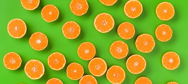 Modello di frutta di fette d'arancia fresche su sfondo verde Vista piatta dall'alto Design pop art creativo concetto estivo Metà di agrumi in stile minimale