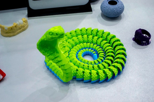 Modello di giocattolo di serpente verde stampato su una stampante d da un oggetto a forma di serpente di plastica fusa creato da d