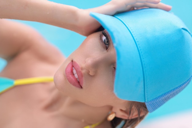 Modello di giovane donna in bikini in piscina posa sexy in vacanza estiva a bordo piscina ragazza abbronzata dentro